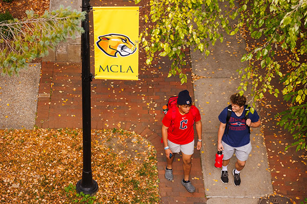 MCLA campus students walking under a MCLA sign
