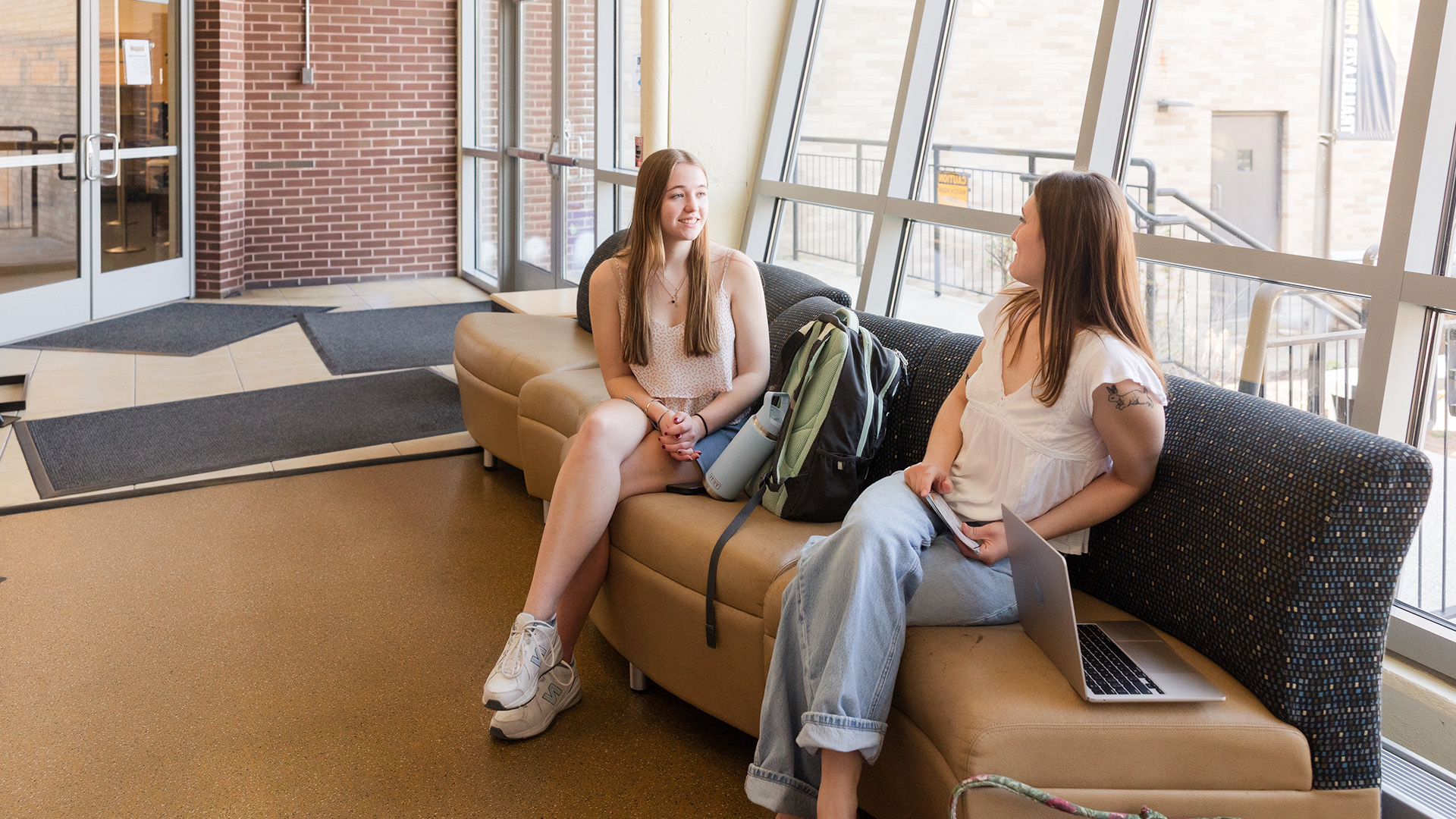 MCLA campus students sitting in a hallway